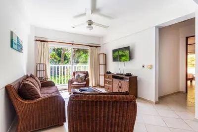 a living room with a couch and chairs and a tv at Alicia Beach, Hispaniola Sol! in Sosúa