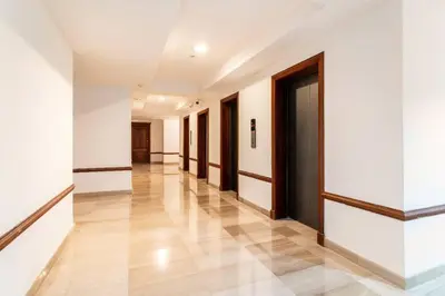 a hallway with white walls and wooden doors at 3 BDR Ocean View luxury Apartment . Sleeps 6 in Santo Domingo