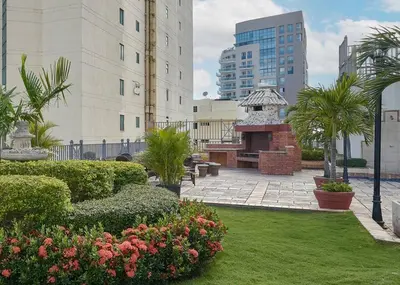 a garden with bushes and flowers in front of buildings at 3 BDR Ocean View luxury Apartment . Sleeps 6 in Santo Domingo