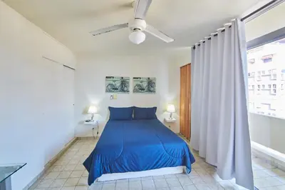 a blue bed in a white room with a window at Rentamos Aparta Estudio for short or long stay in Santo Domingo