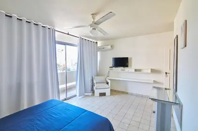 a bedroom with a bed and a chair and a window at Rentamos Aparta Estudio for short or long stay in Santo Domingo