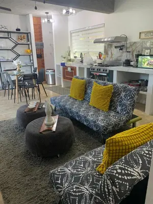 a living room with two couches and a kitchen at VILLA GRANDEZZA in Punta Cana