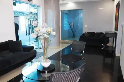 a living room with a glass table with a vase of flowers at Hotel Merey in Santo Domingo
