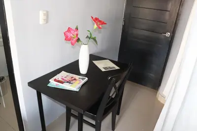 a black table with a vase with flowers on it at Hotel Merey in Santo Domingo