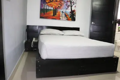 a bedroom with a bed with a black headboard at Hotel Merey in Santo Domingo