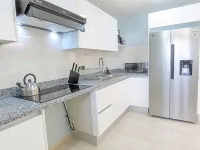 a kitchen with white cabinets and a refrigerator at Cerca de la playa y restaurantes espacio relajante in Punta Cana