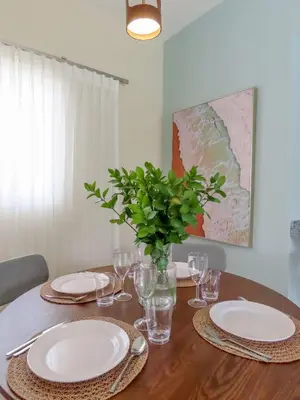 a table with plates and glasses and a vase with a plant at Cerca de la playa y restaurantes espacio relajante in Punta Cana