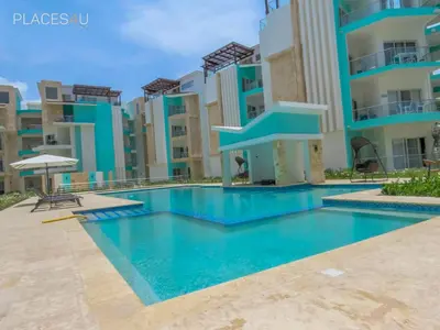 a swimming pool in front of a building at Cerca de la playa y restaurantes espacio relajante in Punta Cana