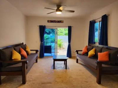 a living room with two couches and a table at Bella Villa Roomy apartment at 5 min walk to the beach in Las Galeras