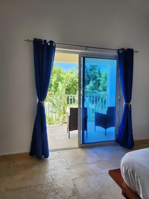 a bedroom with a door open to a patio at Bella Villa Roomy apartment at 5 min walk to the beach in Las Galeras