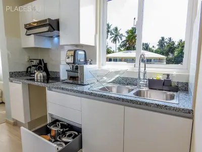 a kitchen with white cabinets and a sink and a window at Hermoso apartamento 1 hab a pasos de la playa in Punta Cana