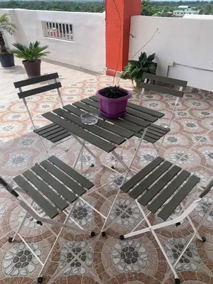 a table and chairs on a patio with a potted plant at Plataview Apartahotel 3B in Monte Plata