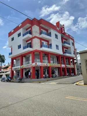 a red and white building on the corner of a street at Plataview Apartahotel 3B in Monte Plata