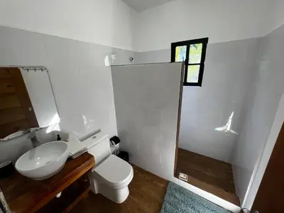 a white bathroom with a toilet and a sink at Villa unter Palmen in Jarabacoa