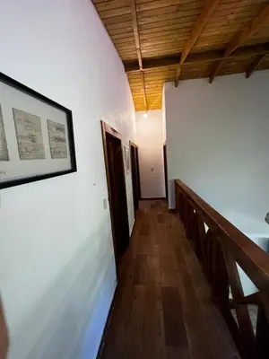 a hallway with white walls and wood floors and a picture at Villa unter Palmen in Jarabacoa