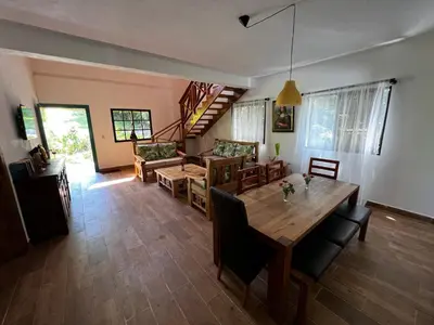 a dining room and living room with a table and chairs at Villa unter Palmen in Jarabacoa