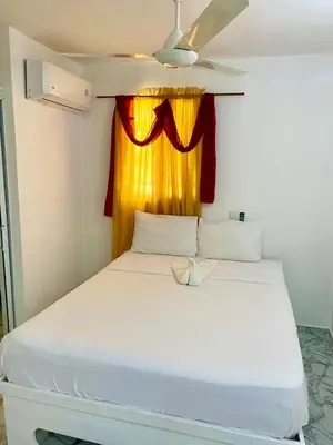 a white bed in a room with a window at Apartamentos felix Las terrenas in Las Terrenas