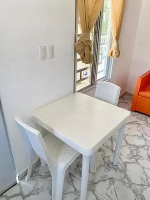 a white table and chairs in a room with a window at Apartamentos felix Las terrenas in Las Terrenas