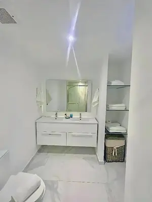 a white bathroom with a sink and a mirror at Ph in Cana Rock Star With Golf View And Pool in Punta Cana