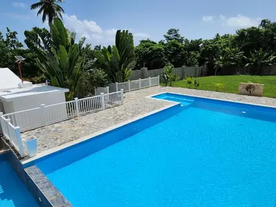 a blue swimming pool with a fence around it at Bella Villa room with large pool and close to beach in Las Galeras