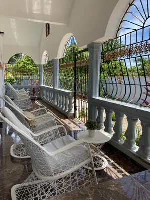 a balcony with white chairs and a railing at Casa Jacaranda -10 pax, Cerca de la Playa in Las Galeras