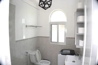 a bathroom with a toilet and a sink and a window at Tamarindo Dominicus by Mireya in La Laguna