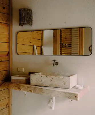 a bathroom with a stone sink and a mirror at Buena Vida Macao 7 habitaciones in Salado