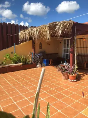 a house with a tiled courtyard with a thatch roof at Condo Penthouse Batey Dominicus in Bayahibe