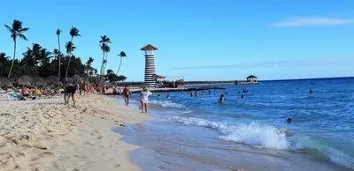 a beach with a lot of people in the water at Condo Penthouse Batey Dominicus in Bayahibe