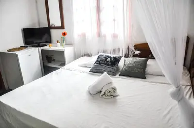 a bedroom with a white bed with towels on it at Casa Delfin Guest House in Las Terrenas