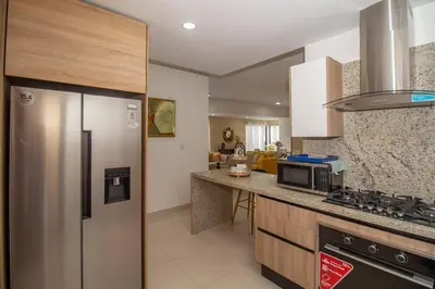 a kitchen with a refrigerator and a stove top oven at Brand New Luxury Home in Santo Domingo