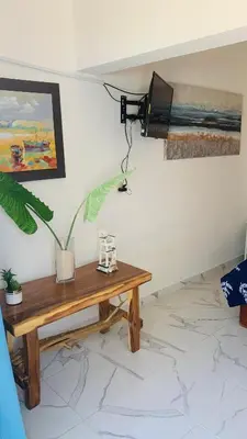 a room with a table and a television on a wall at La Isla Bonita in Punta Rucia