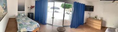 a bedroom with blue curtains and a bed and a sliding glass door at La Isla Bonita in Punta Rucia