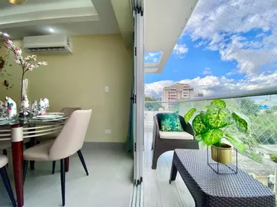 a living room with a table and chairs and a large window at Cozy City Center Condo, Full AC in Los Prados