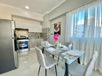 a dining room with a table and chairs and a kitchen at Cozy City Center Condo Full AC in Santo Domingo
