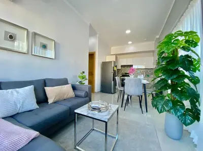 a living room with a blue couch and a table at Cozy City Center Condo Full AC in Santo Domingo