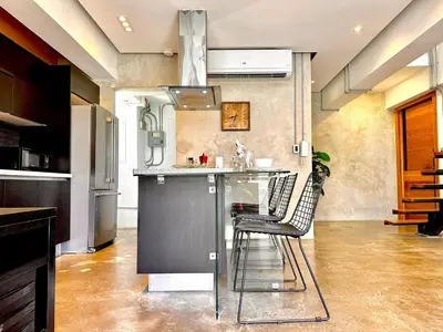 a kitchen with a bar with two chairs at a counter at New Loft Apt Full AC King Bed in Santo Domingo