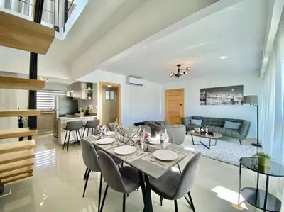 a dining room and living room with a table and chairs at Stylish Apt Full AC King Bed in Los Prados