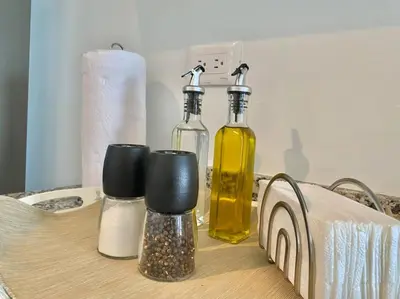 a table with two bottles and cups on it at Stylish Apt Full AC King Bed in Los Prados