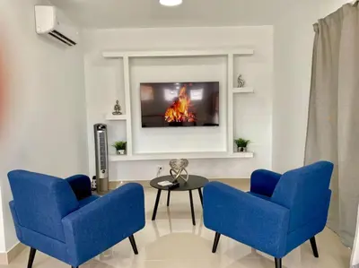 a living room with two blue chairs and a table at Stylish Apt Full AC King Bed in Los Prados