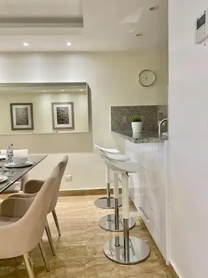 a restaurant with stools and a counter with a sink at Lovely Sto Dgo Center Apt in Santo Domingo