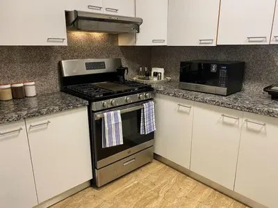 a kitchen with a stove and a microwave at Lovely Sto Dgo Center Apt in Santo Domingo