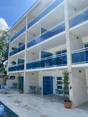 an apartment building with blue balconies next to a pool at New Garden Hotel in Sosúa