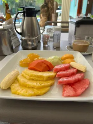 a plate of fruits and vegetables on a table at New Garden Hotel in Sosúa