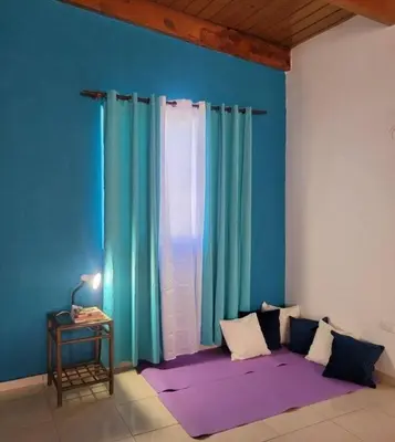 a room with blue and green curtains and a table at Casa angelina in Sosúa