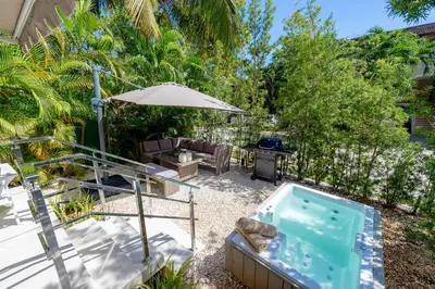 a backyard with a hot tub and an umbrella at RIBERAMAR Las Terrenas, Samana in Las Terrenas