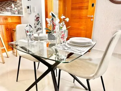 a glass table with two chairs and a plate on it at Beautiful Condo in Bella Vista in Los Prados