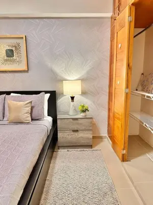 a bedroom with a bed and a night stand with a lamp at Beautiful Condo in Bella Vista in Los Prados