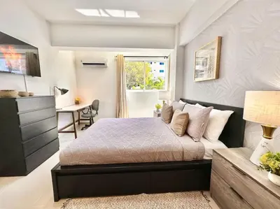 a bedroom with a bed and a desk and a window at Beautiful Condo in Bella Vista in Los Prados