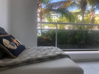 a couch in a room with a large window at Estrella Dominicus con hermosa piscina! 1st floor in La Laguna